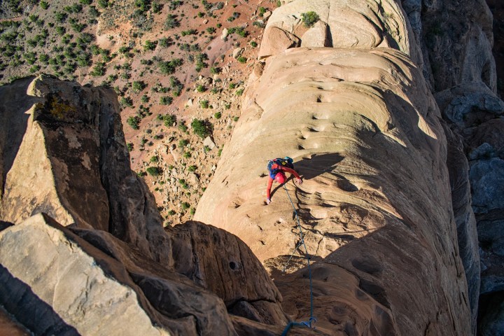a person standing in front of a large rock