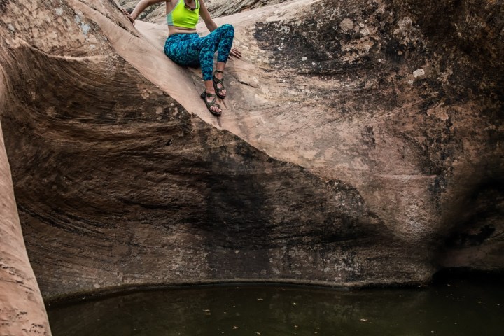 a man sitting on a rock next to water