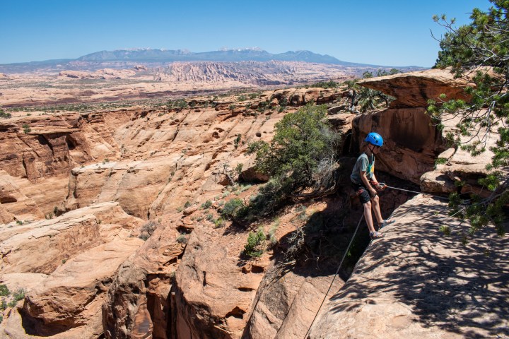 a man riding a bike down a dirt road in a canyon
