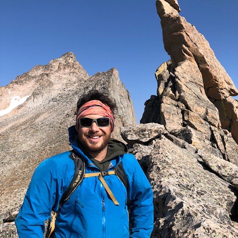 a man standing in front of a mountain