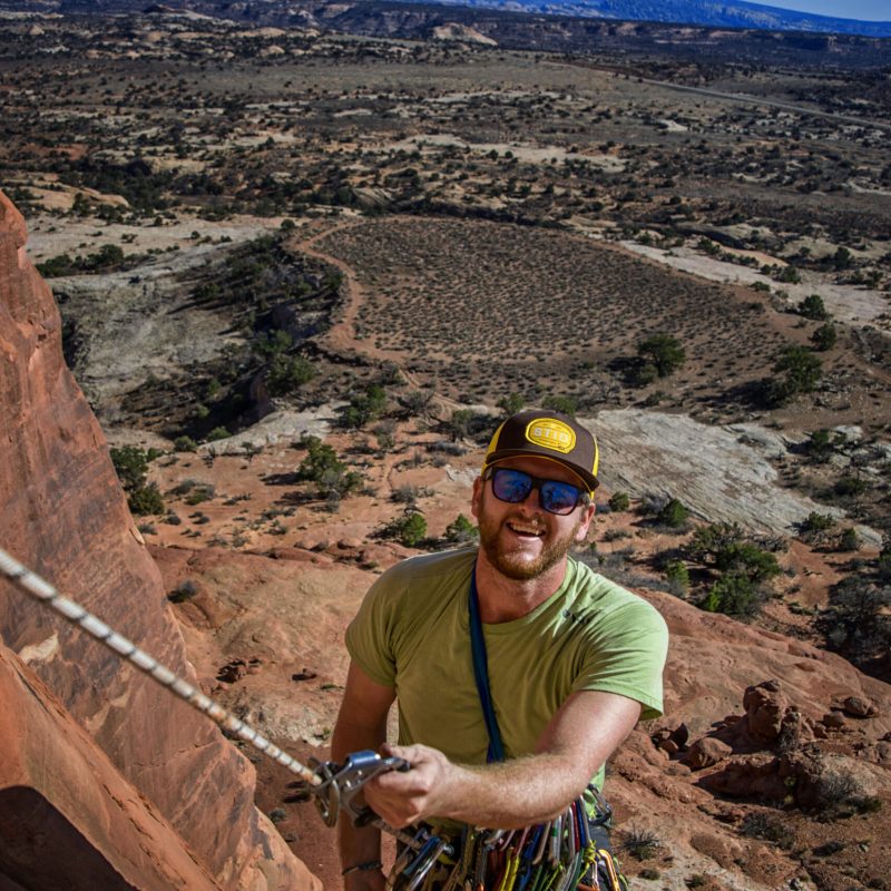 a man that is standing in the dirt with a mountain in the background