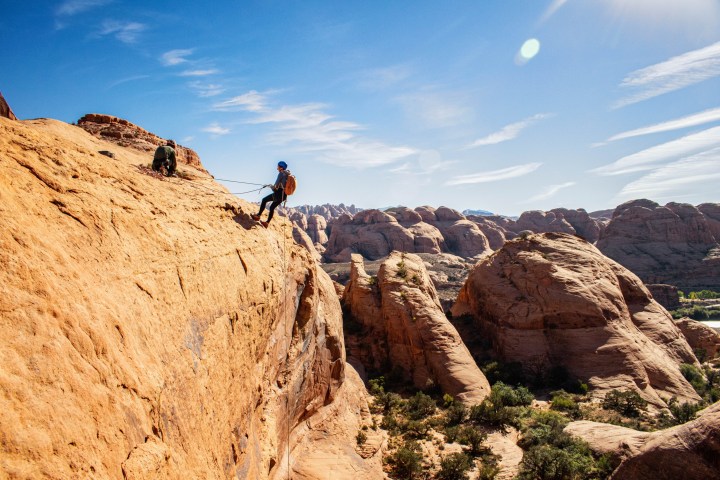 a man flying through the air on a rocky hill