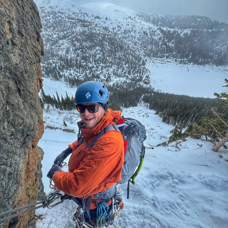 a man riding a snowboard down a snow covered mountain